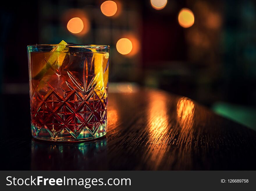 Fresh colorful alcoholic cocktail with lemon and ice in the bar