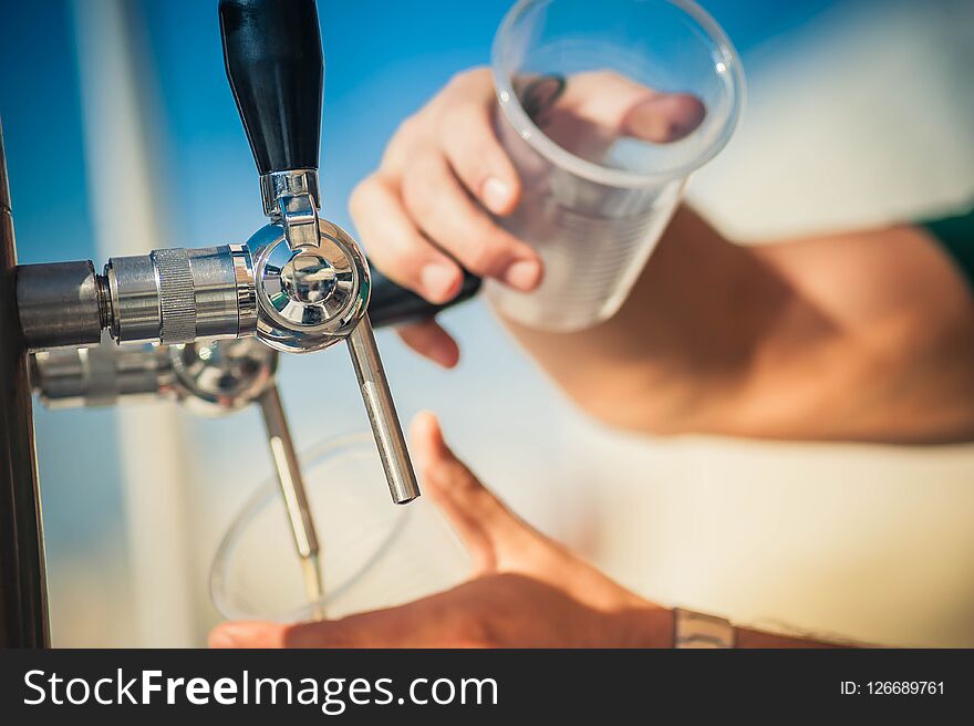 Hand of bartender pouring a beer in tap