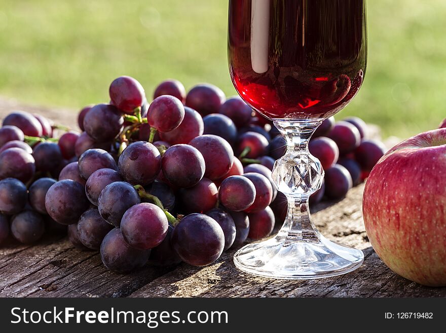 Red wine, grapes and apples on a wooden background. Red wine, grapes and apples on a wooden background.