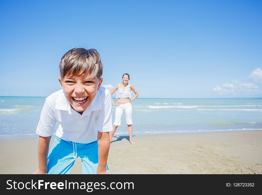 Adorable boy with his sister have fun on the beach.