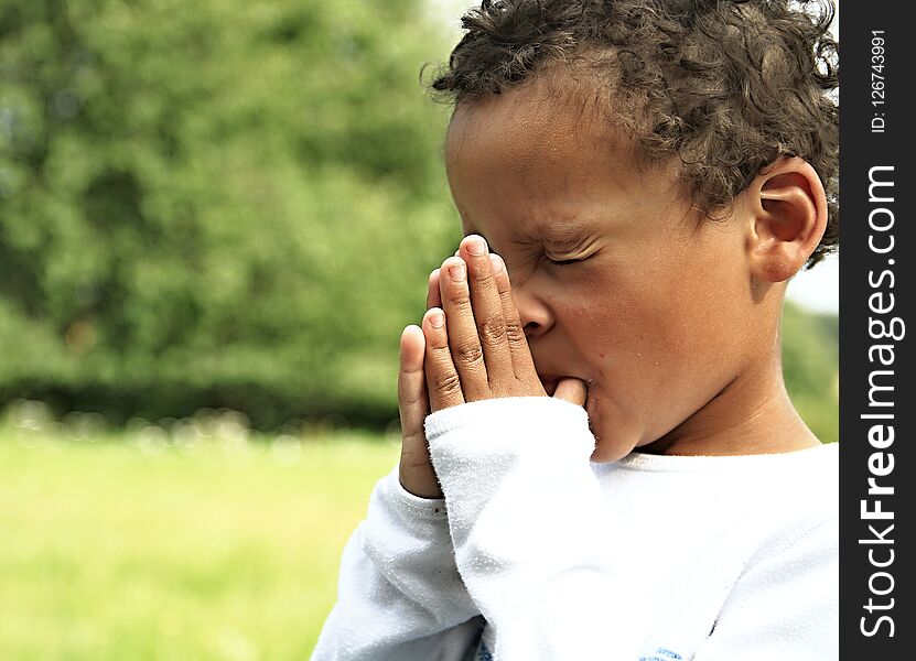 Little boy praying to God with hands held together