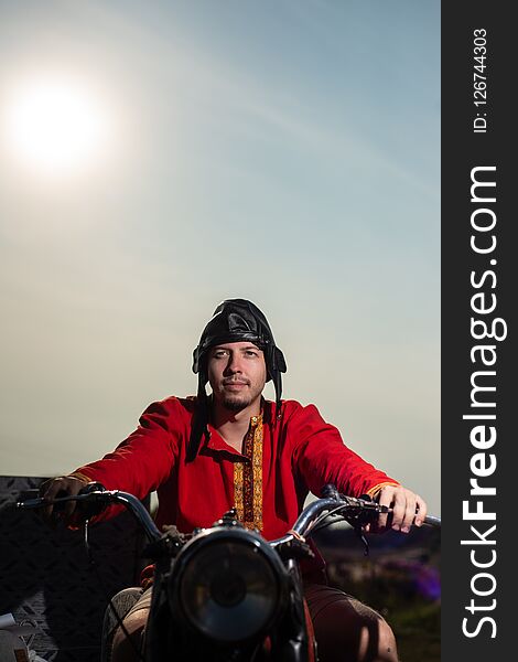 Russian motorcyclist on old Soviet motorcycle on sky background