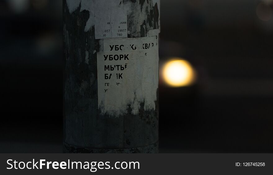 Paper advertisement on a lamp post with apartment cleaning and washing service text at the street of Saint-Petersburg