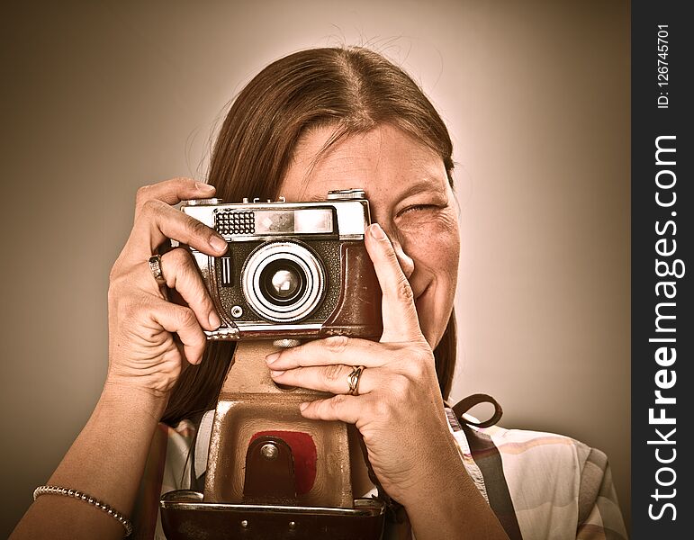 Woman with old camera on grey background
