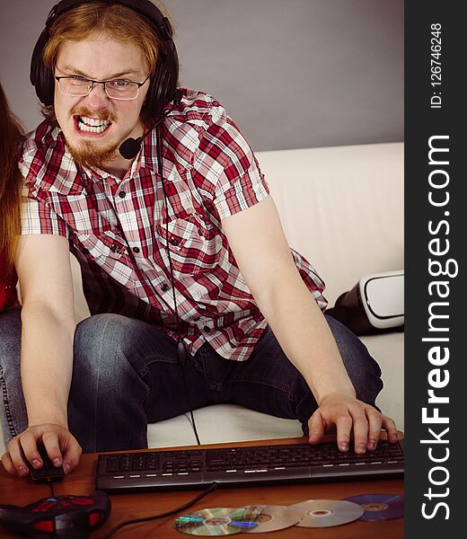 Nerd geek young adult man playing on the video console holding game pad. Gaming gamers concept. Nerd geek young adult man playing on the video console holding game pad. Gaming gamers concept.