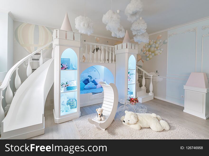 Interior of a spacious children`s room. decorative castle with bed inside, game slide and stairs