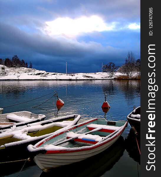 Boats Under Snow In Finland. Fishing boat under a layer of snow and ice