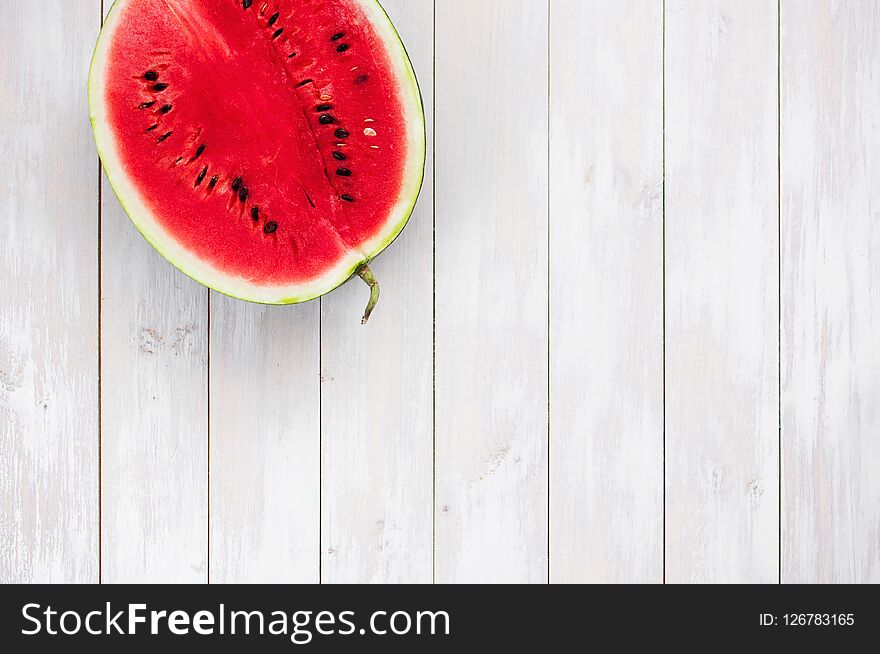 Watermelon on a light rustic wooden background top view. Juicy ripe watermelon, summer food background