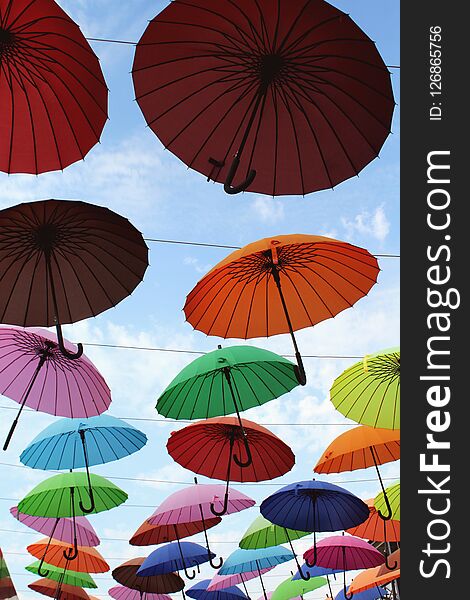 Street installation with colorful, beautiful umbrellas floating in the air against the sky, close-up as a background. Street installation with colorful, beautiful umbrellas floating in the air against the sky, close-up as a background.