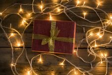 Christmas Gift And Lights On Vintage Wooden Background Royalty Free Stock Photo