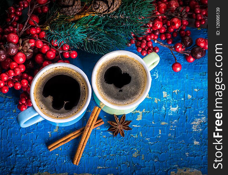 Cups of fragrant coffee on a Christmas background of fir branches, berries and cones. Cups of fragrant coffee on a Christmas background of fir branches, berries and cones