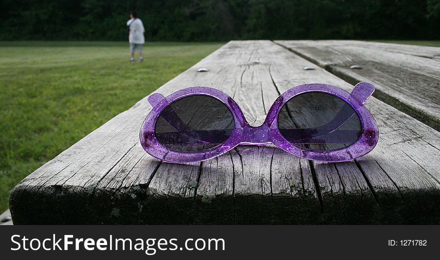 Pink sunglasses on a park bench
