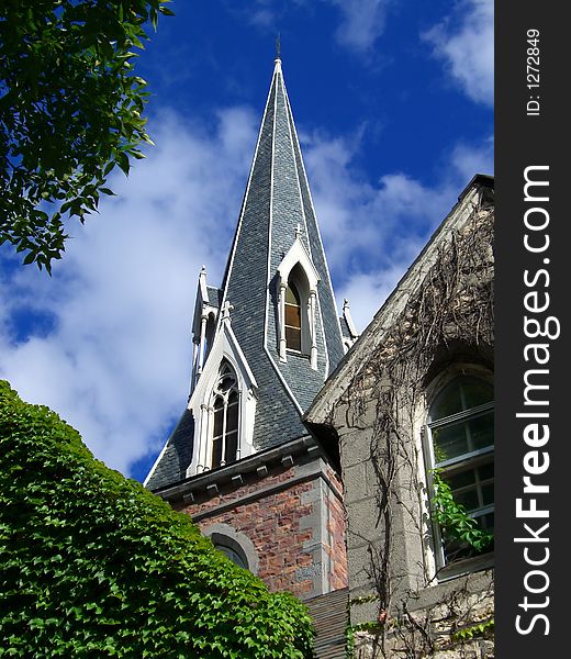 Church steeple with ivy against blue sky