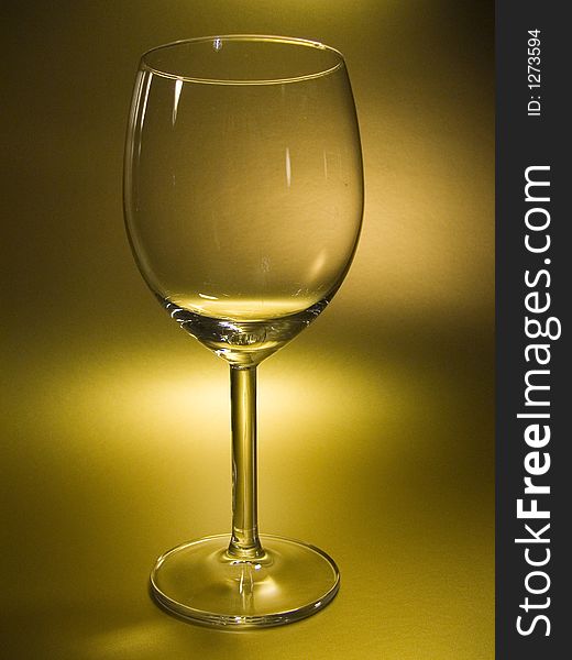 Empty wineglass in gold fon