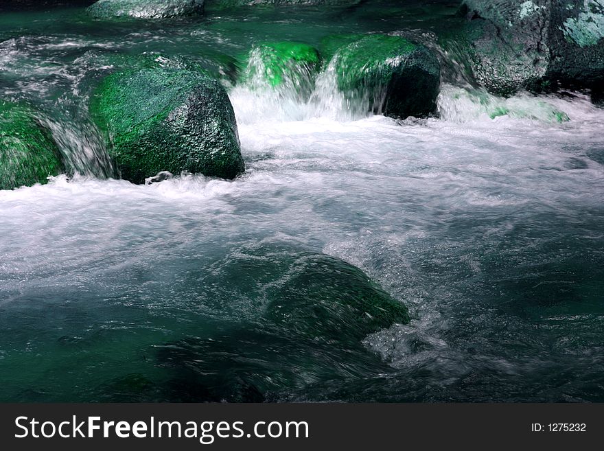 A small stream with rocks and white water. A small stream with rocks and white water.