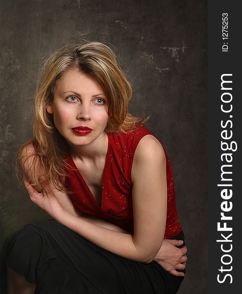 Portrait of the girl in a red dress and the red lips, a tired look. Portrait of the girl in a red dress and the red lips, a tired look