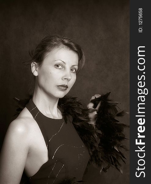 Portrait of the beautiful woman in an evening dress with feathers. b/w+sepia. Portrait of the beautiful woman in an evening dress with feathers. b/w+sepia