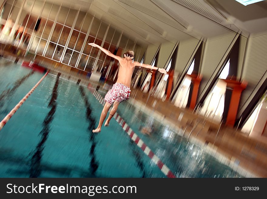 Indoor swimming pool fun, girl diving, motion blur