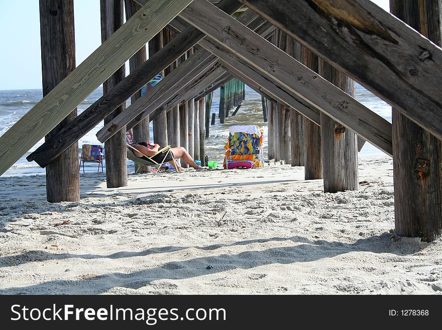 Lady chilling out under pier. Lady chilling out under pier