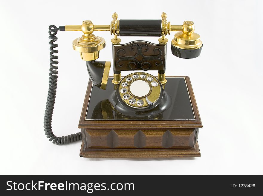 Old style telephone on a wooden base with a white background. Old style telephone on a wooden base with a white background.