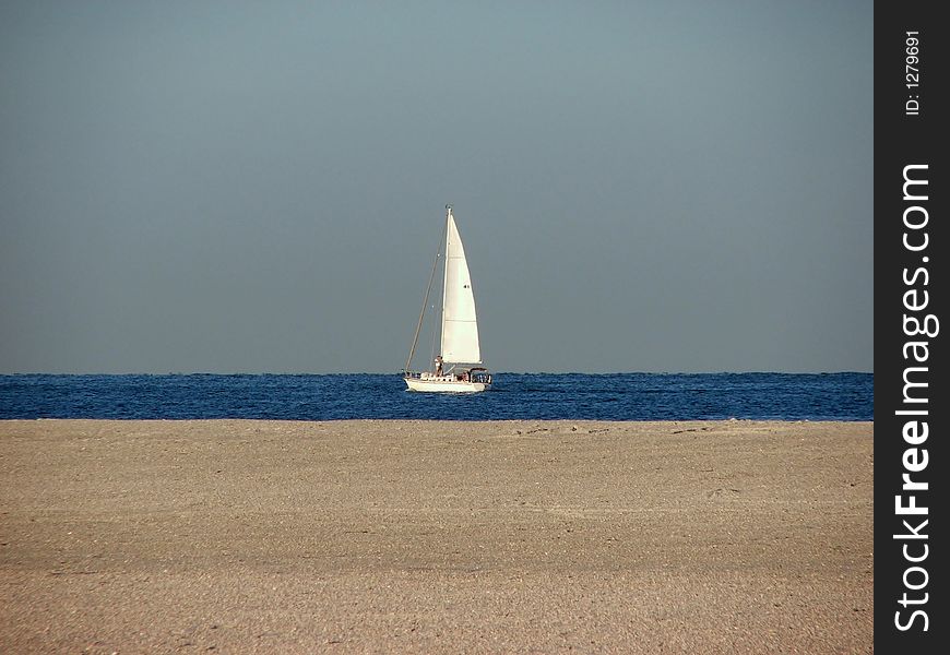 This sailboat heads out for a day of sailing on the gulf. This sailboat heads out for a day of sailing on the gulf.