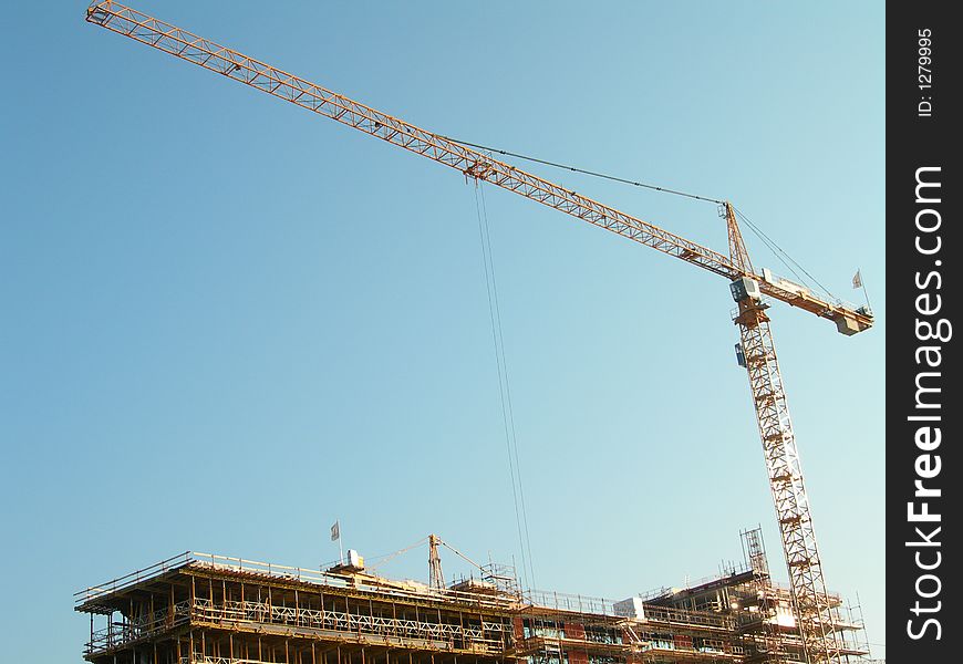 Crane on construction site and blue sky.