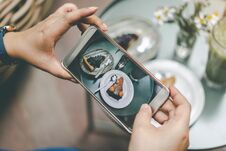 Woman`s Hand Was Photographed Cake By Her Smartphone To Get Into Royalty Free Stock Photos