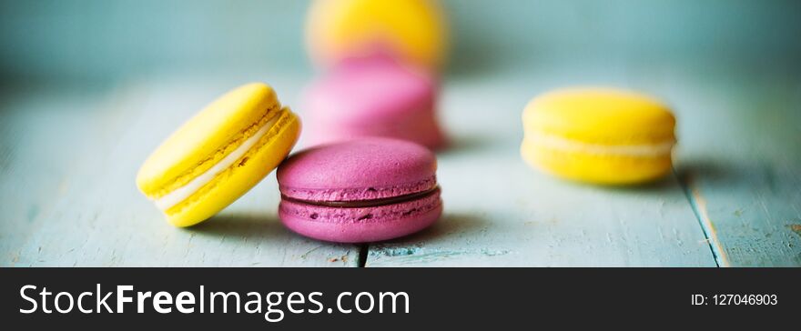 Group of pastel color macaroons on blue textured shabby chic background, with room for copy space