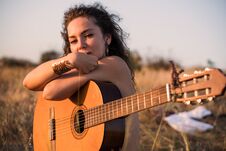 Free Naked Contemplative Brunette Girl Sitting With Guitar In The Field With Taked Off Clothes On Background Stock Image - 127057071