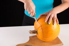 Girl Hand Cuts Big Orange Pumpkin On Wooden Board Royalty Free Stock Photography Girl Hand Cuts Big Orange Pumpkin On Wooden Board Royalty Free Stock Photography