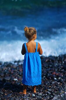 Little Girl In A Blue Dress Playing On The Paradisos Beach In Santorini Royalty Free Stock Photo