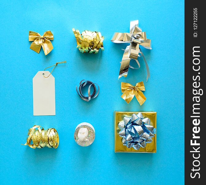 Golden and silver Christmas gift boxes and decorations on blue background. Flat lay. Top view