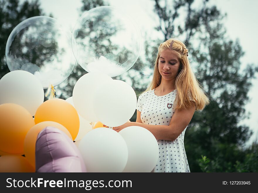 Young Girl With Balloons On Nature Background