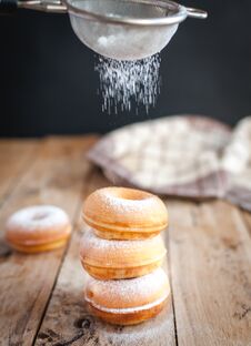 Stacked Donuts With Powdered Sugar On Wooden Background Royalty Free Stock Photography