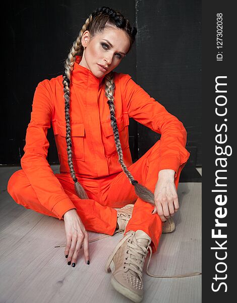 Female mechanic with braids in oranzhevom jumpsuit. Female mechanic with braids in oranzhevom jumpsuit