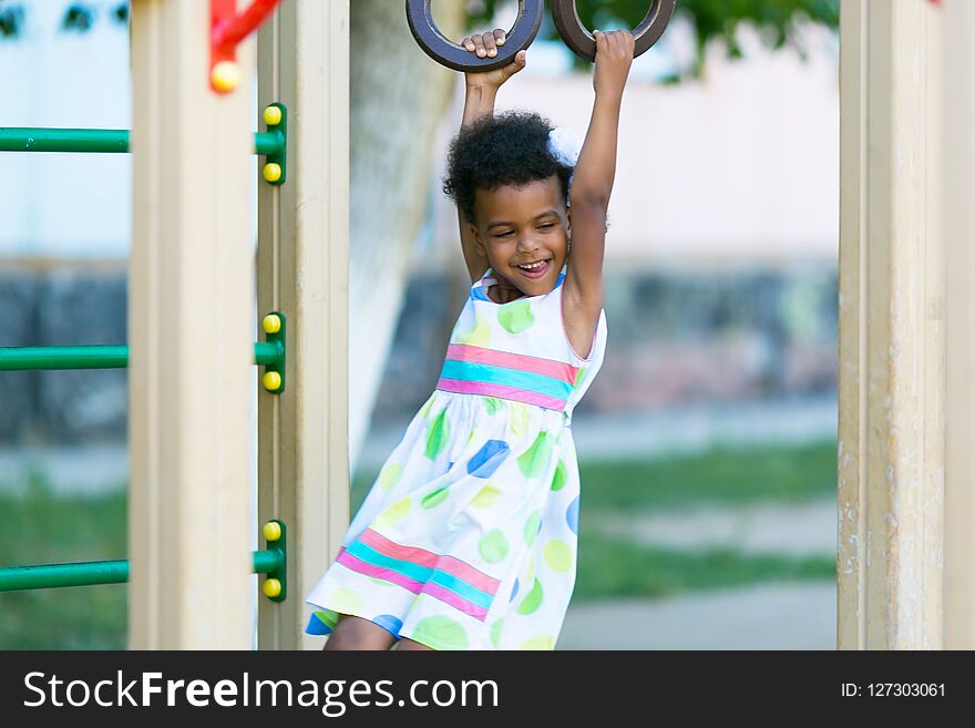 African American girl plays on a sports playground. African American girl plays on a sports playground.