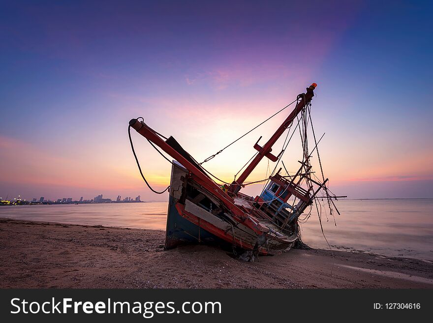 Abandoned Shipwreck Of Wood Fishing Boat On Beach At Twilight Ti