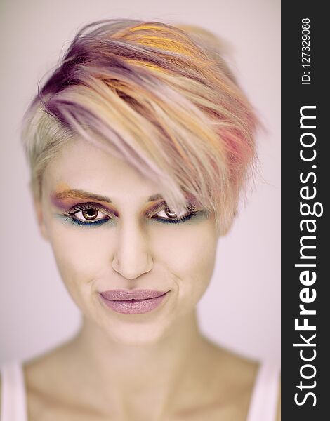 Fashion beautiful blonde woman with short haircut and colorful pastel hair and make up