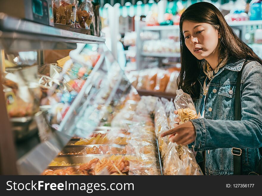 Female customer is holding a bag of dried fruit.