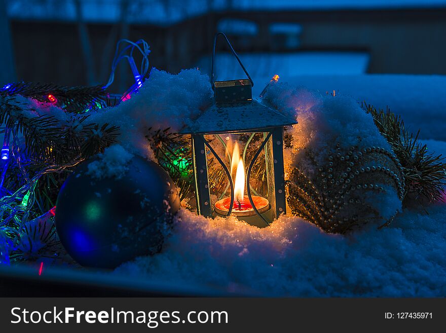 Lantern with burning candle and christmas decoration on fresh snow. Lantern with burning candle and christmas decoration on fresh snow