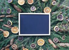 Christmas, New Year Winter Holiday Composition. Empty Framed Board On Green Fir-tree Branches Decorated With Dried Orange Slices A Royalty Free Stock Photos