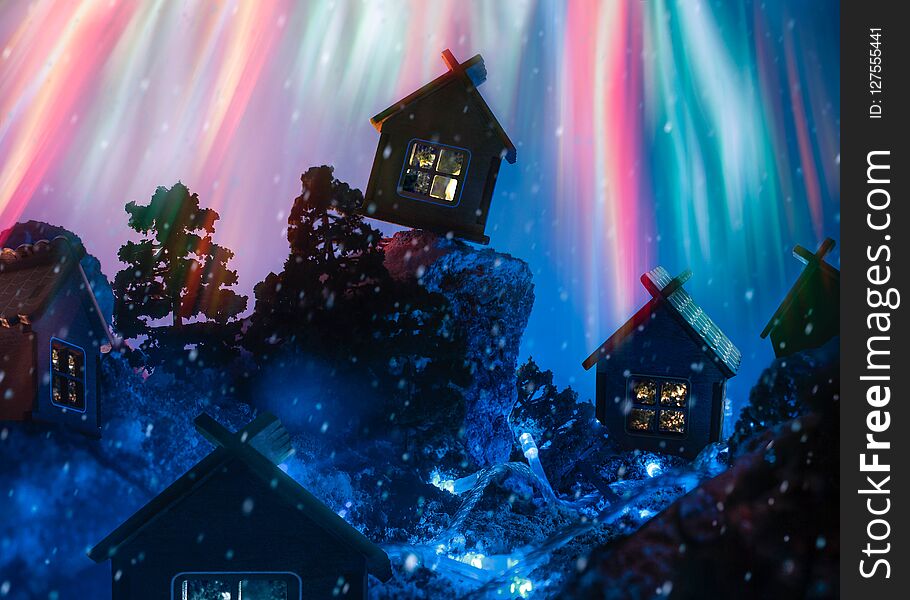 Night winter landscape with huts and fireworks