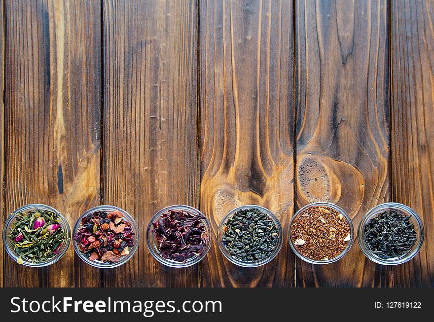 Selection of assorted teas in transparent little bowls on natural background