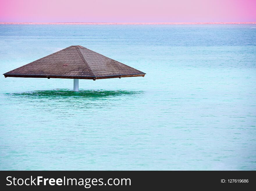 Sun umbrella in the water. Beautiful blue sea. The Dead Sea