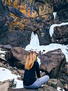 The Woman Sitting On The Rock Mountain. Royalty Free Stock Photography