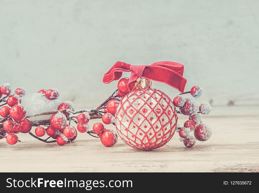 Red an white christmas - twig with berries on white wooden background, retro toned