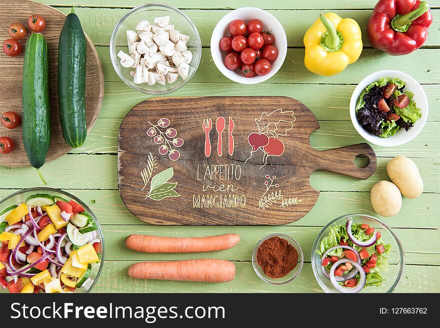 Top view of wooden cutting board and fresh raw vegetables on wooden table. Top view of wooden cutting board and fresh raw vegetables on wooden table