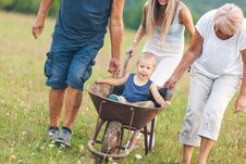 Free Family Pushing Their Small Child In A Wheelbarrow Stock Photos - 127692543