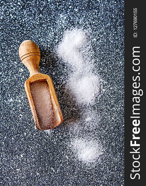 Crystals Of Shallow Salt In A Scoop, Spoon On A Dark Gray Table.