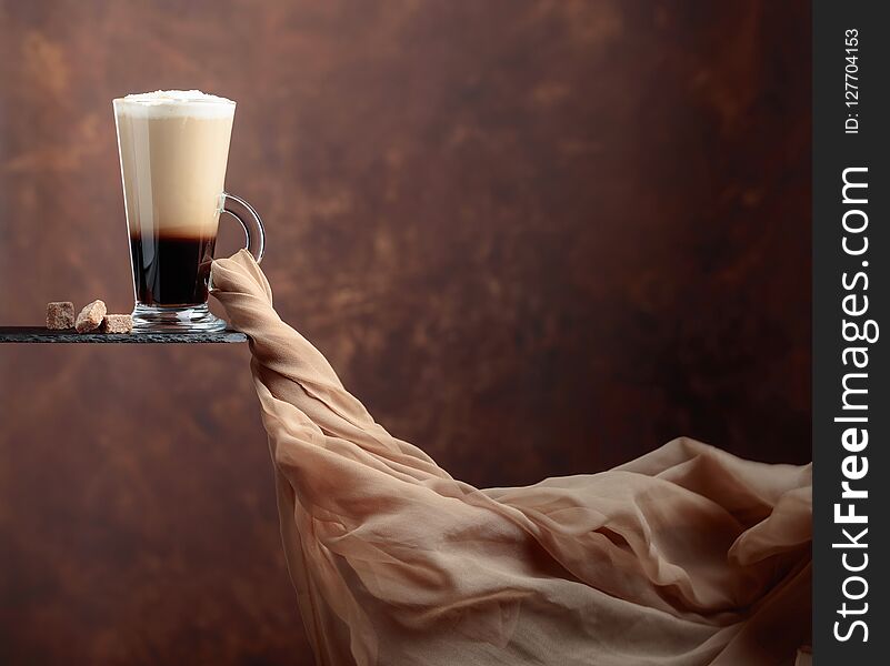 Coffee drink or cocktail with cream on a brown background. Evolving in the wind chiffon scarf. Copy space for your text. Coffee drink or cocktail with cream on a brown background. Evolving in the wind chiffon scarf. Copy space for your text.